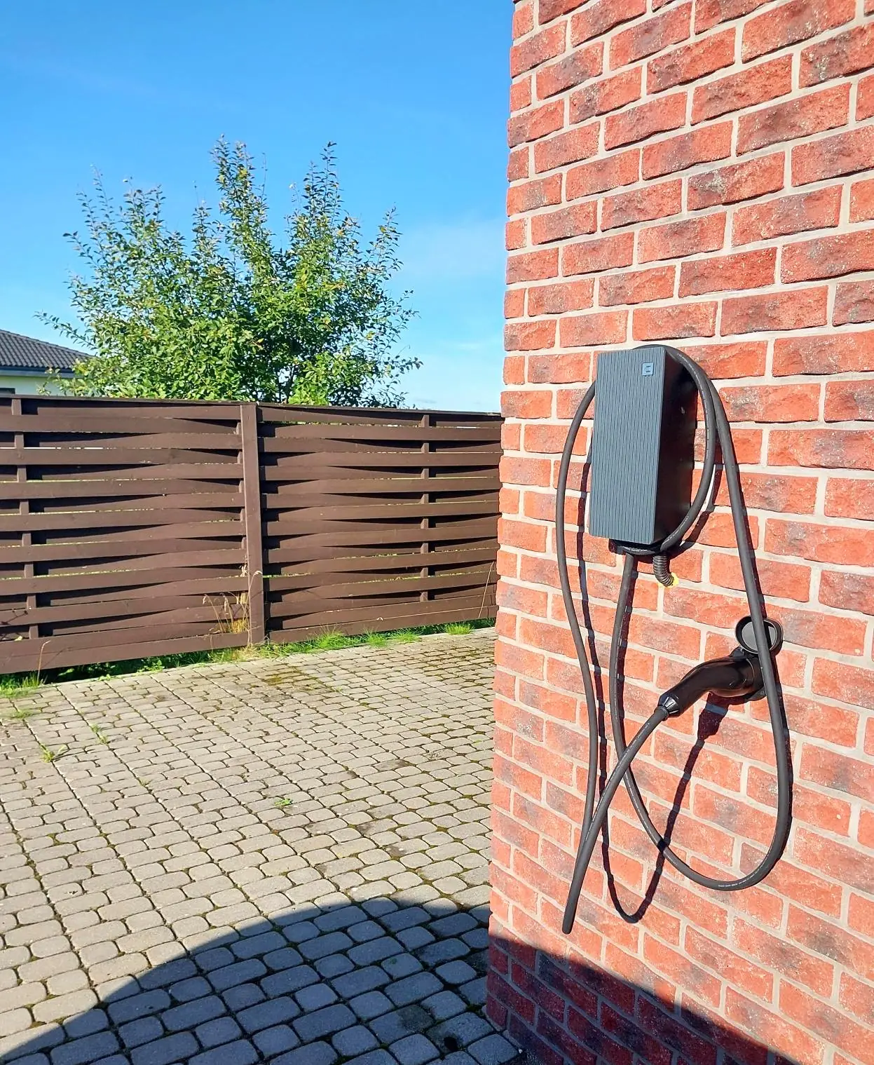 Elbillader på en teglvegg ved innkjørselen