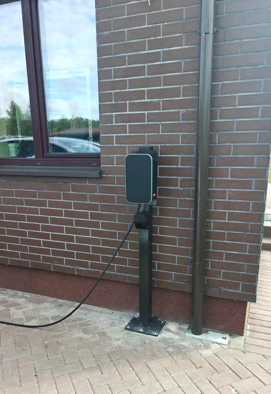 Elbillader på en stolpe foran en teglvegg