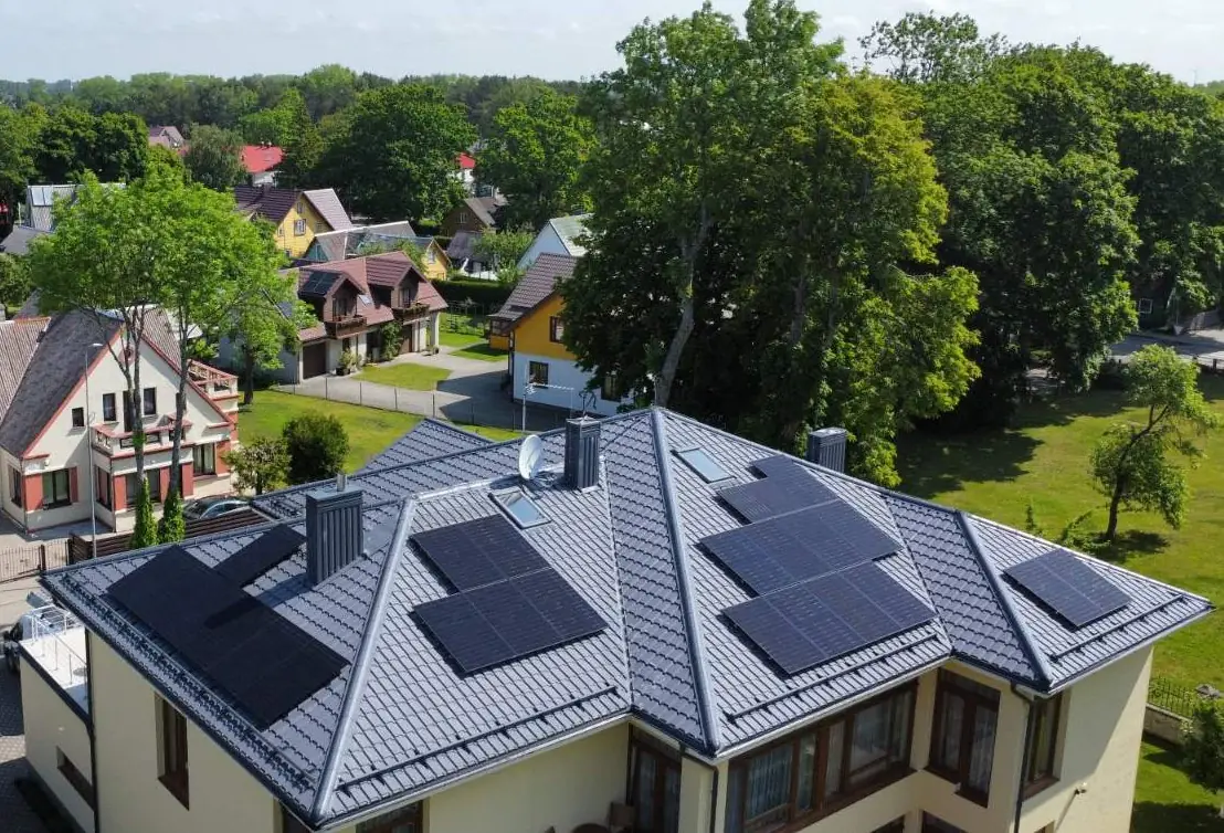 Solcellepaneler på et valmtak i et boligområde